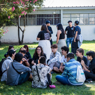 Estudiantes sentados en el pasto