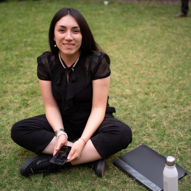 Integrante del elenco sentada en el pasto