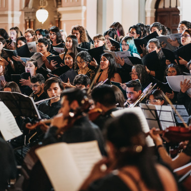 Orquesta leyendo partituras mientras tocan
