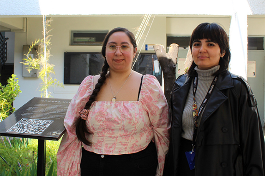 Two women pose for the camera in the courtyard of the Technological Faculty