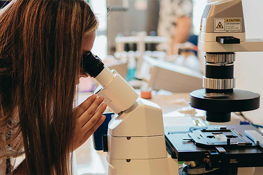  Scientist looking through a microscope.