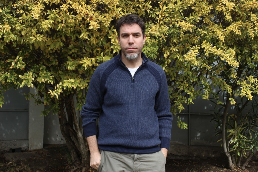 Hombre posa frente a la cámara y de fondo se ve un árbol 