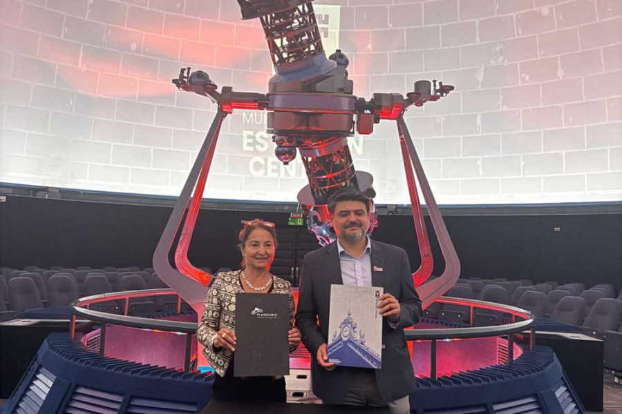 Mujer (izquierda) y hombre (derecha) sostienen documento en Planetario