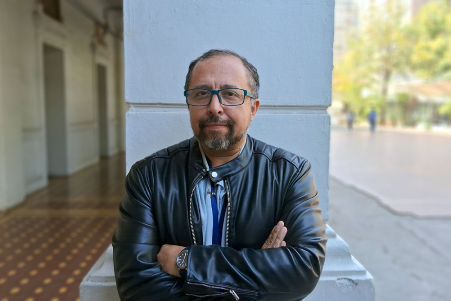 Académico Antonio Letelier de brazos cruzados posando frente a la camara 