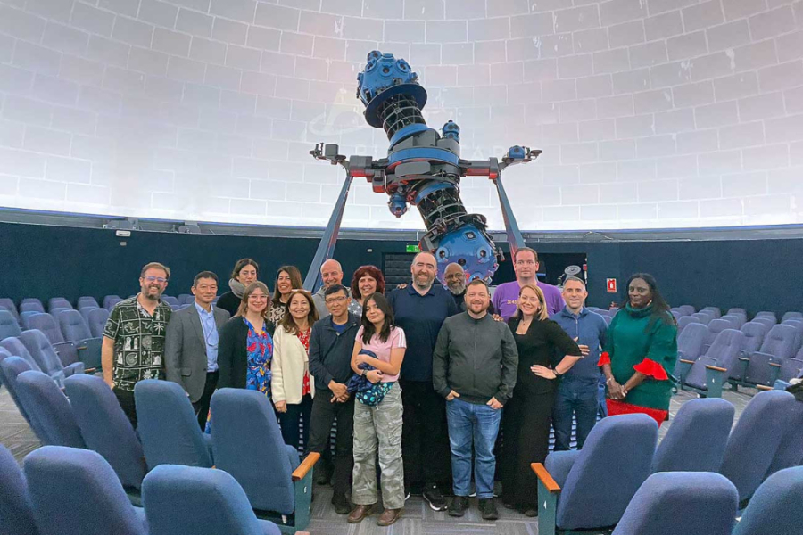 Vicerrectora de Vinculación con el Medio, Dra. Ana María Fernández, la directora ejecutiva Fundación Planetario Usach, Jacqueline Morey, junto a investigadores del área, posan al interior del Planetario Usach. De fondo se puede apreciar el proyector Carl Zeiss VI usach