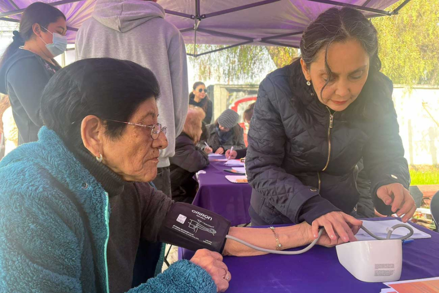 Operativo de salud en Villa Portales. En la imagen se puede apreciar a una profesional de la salud tomando a la presión a una vecina.