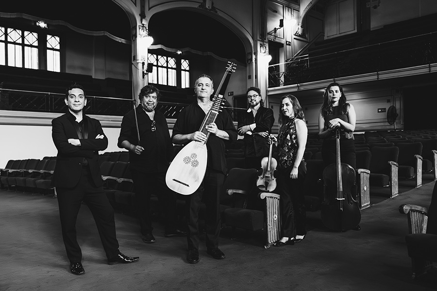 Músicos del elenco Syntagma posan en el Teatro Aula Magna Usach. La fotografía es en blanco y negro