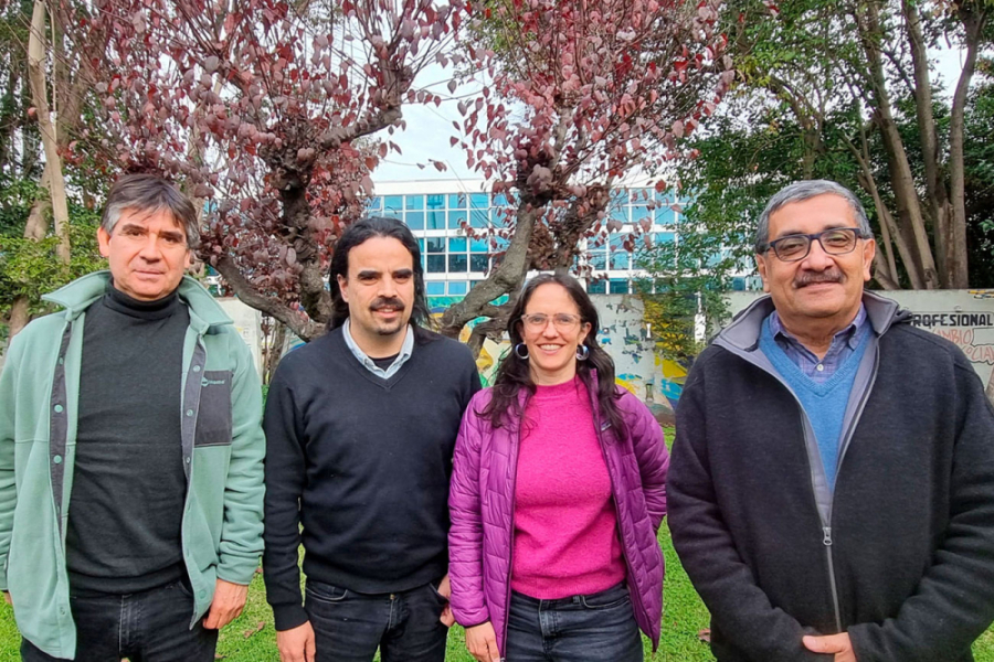 Académicos del Magíster en Historia posan a la cámara en los jardines de enfrente de la fachada principal de la Facultad de Humanidades 