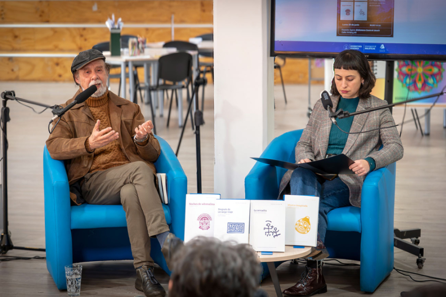 Imagen muestra a dos personas sentadas dirigiéndose al público