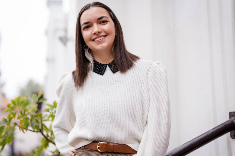 En la fotografía aparece la jefa del Departamento de las Culturas y las Artes, Johanna Chacón Aguirre. Lleva un chaleco Blanco y sus cabello llegan a sus hombros. Está situada en las afueras del departamento que dirige
