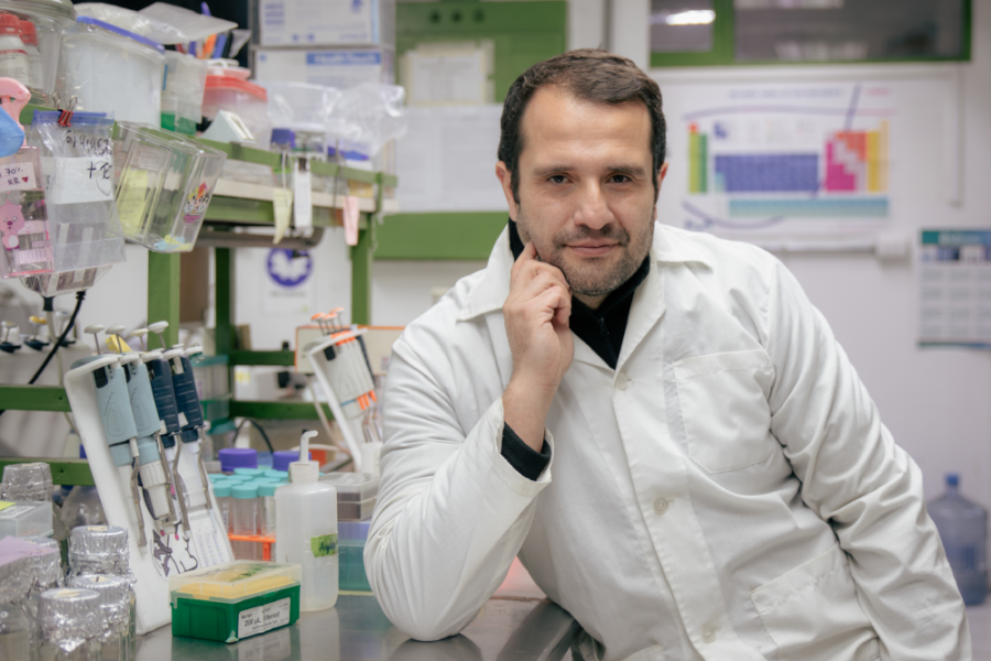 En la imagen aparece el Dr. Carlos Vera, en su laboratorio de trabajo. El investigador lleva un delantal blanco y es acompañado por múltiples máquinas de laboratorio.