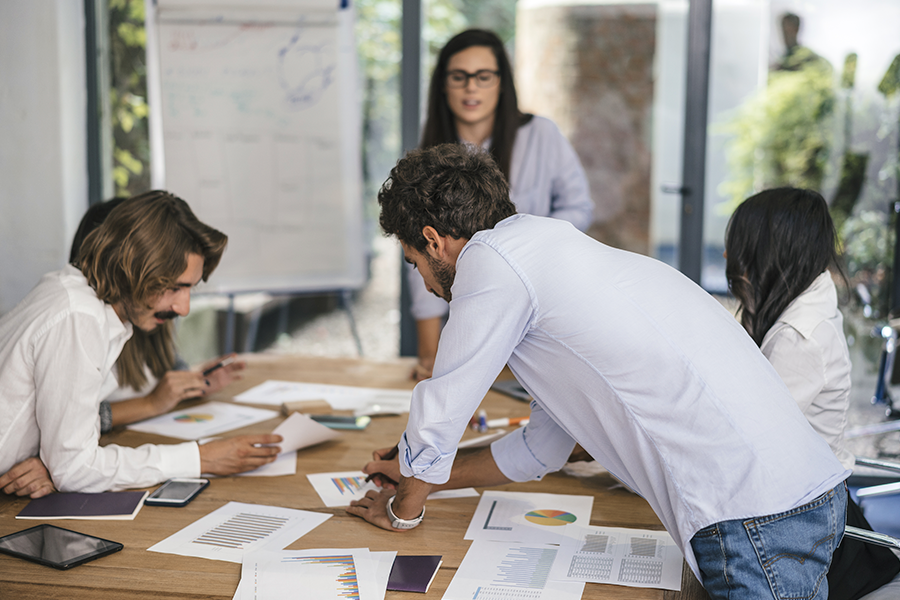 A group of people in a collaborative workshop with documents and charts.