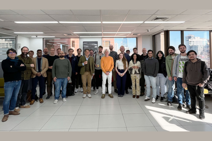 Grupo de personas posa de pie frente a la cámara, alineadas una al lado de la otra, formando una fila o ligeramente escalonadas para que todos sean visibles