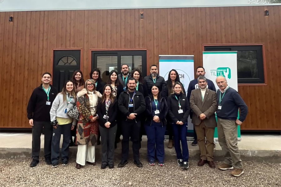 Autoridades y estudiantes de la Facultad de Ciencias Médicas posan delante de los nuevos módulos de atención en Til Til. La estructura es de containers y forrados en madera café oscura. 