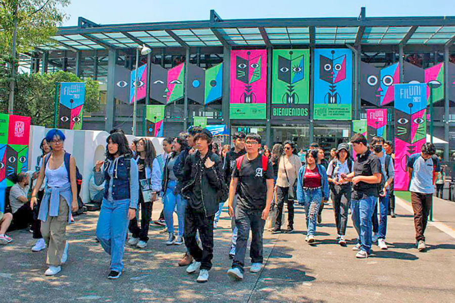 Estudiantes saliendo de la Filuni. De fondo, material publicitario expuesto en el frontis del edificio que acogió el evento