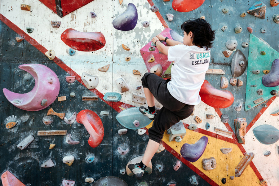 Estudiante Usach sube por muro de escalada.
