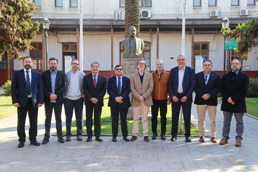 Autoridades de la Facultad de Ingeniería y personeros de la empresa Innovation and Flying Technologies posan a la cámara en el Patio de Los Perros en la edificio de la Escuela de Artes y Oficios