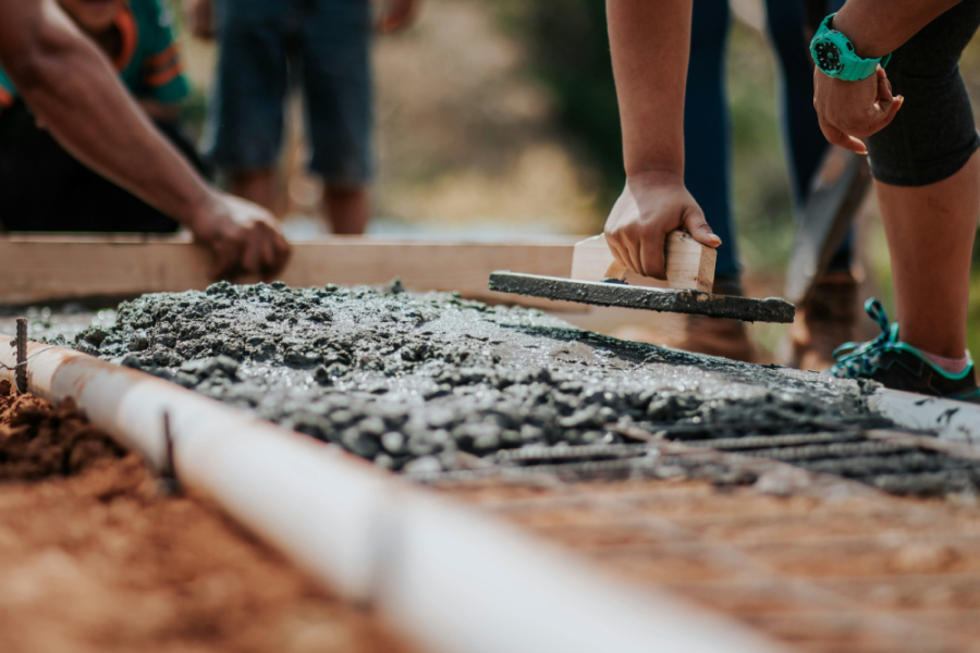 En la fotografía aparece muestra del nuevo hormigón. De fondo, las manos de unos trabajadores que manipulan algunas herramientas sobre el hormigón.
