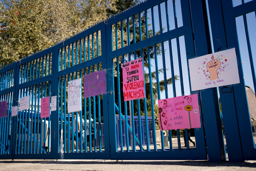 En la imagen aparece la entrada principal de nuestra universidad por la Alemeda (reja azul) con carteles alusivos a la violencia de género