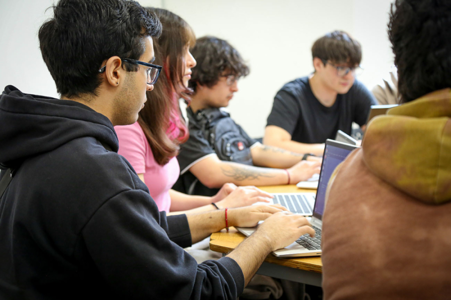 En la imagen se muestran cuatro estudiantes con sus computadores