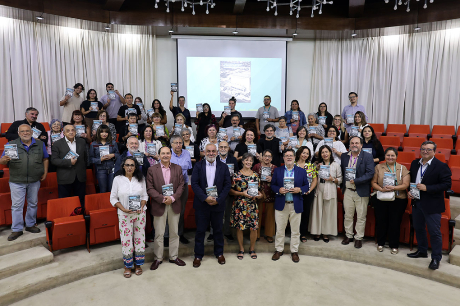 En la fotografía aparecen los asistentes al lanzamiento junto a un ejemplar del libro, en el Salón de Honor Usach