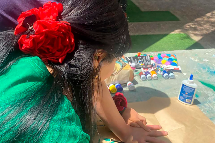 En la imagen se muestra una mujer trabajando en un papelógrafo con témperas de colores