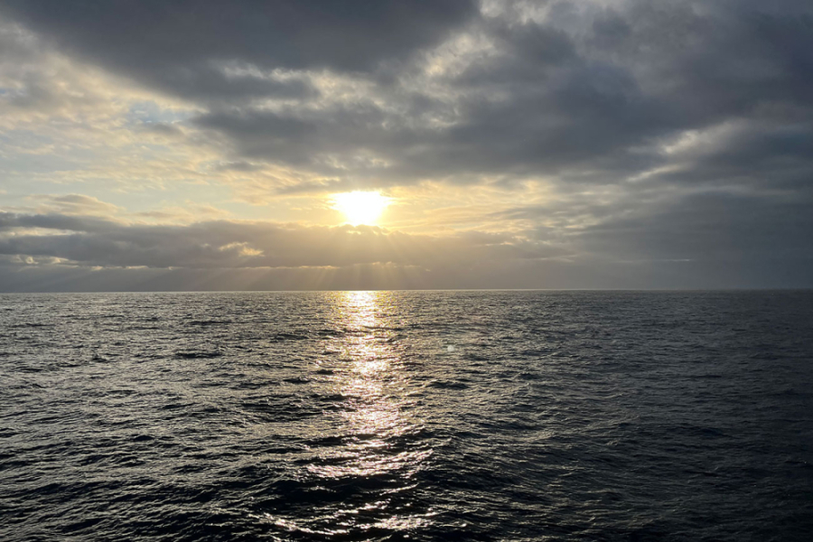 La foto muestra el horizonte, con una puesta de sol en el mar