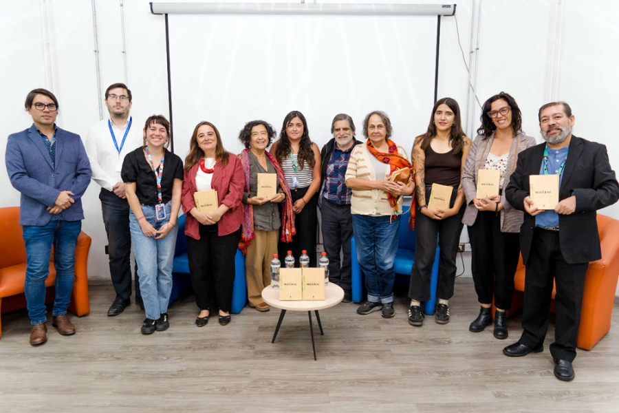 En la imagen se muestra al equipo detrás de la creación del libro, en la sala Gabriela Mistral, sosteniendo el libro-objeto presentado