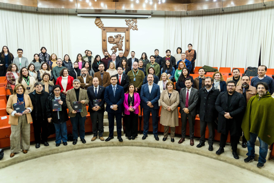 La imagen muestra a las y los asistentes a la ceremonia, reunidos en el salón de honor de la universidad