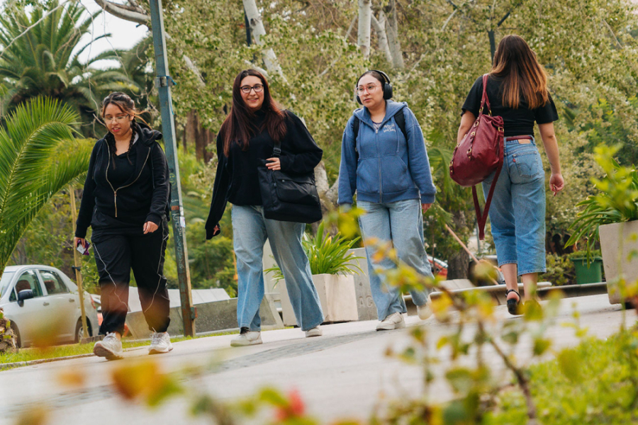 En la imagen aparecen 4 estudiantes de nuestra universidad caminando por el sector de arquitectura y periodismo