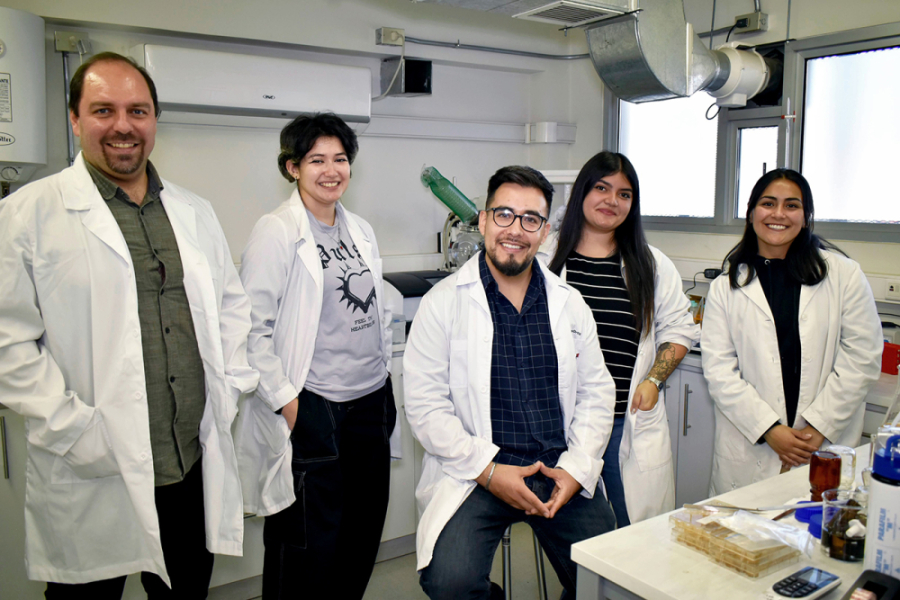 En la imagen aparece el equipo de académicos e investigadores estudiantes que llevan adelante el proyecto. Están vestidos con delantales blancos en el laboratorio de trabajo.