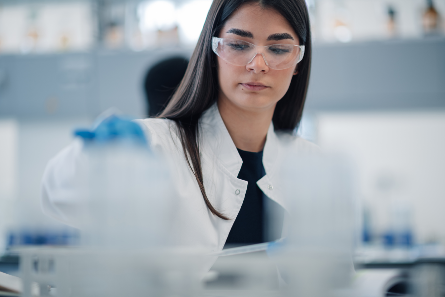 Una científica con gafas de seguridad trabajando en un laboratorio.