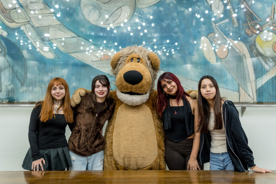 La imagen muestra a las estudiantes del proyecto posando junto a usachin en el Salón de Honor de la Universidad
