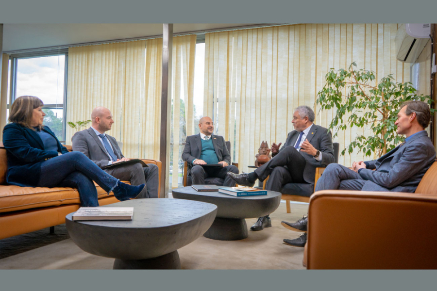 La imagen muestra a las autoridades reunidas sentadas conversando en la oficina del rector