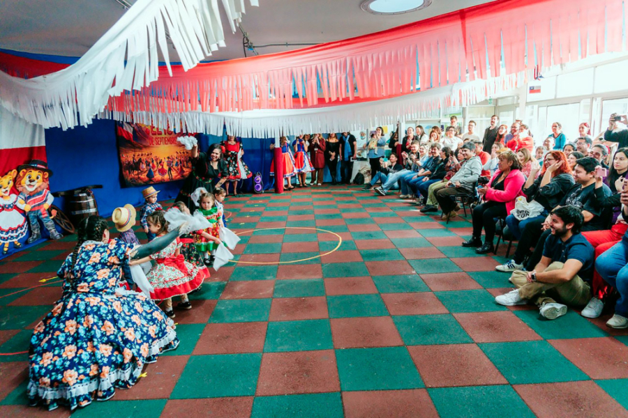 En la imagen aparecen niños y niñas de la Sala Cuna y Jardín Infantil Usach vestidos con el traje nacional de cueca. Bailan frente a sus padres, tías y autoridades de la universidad.