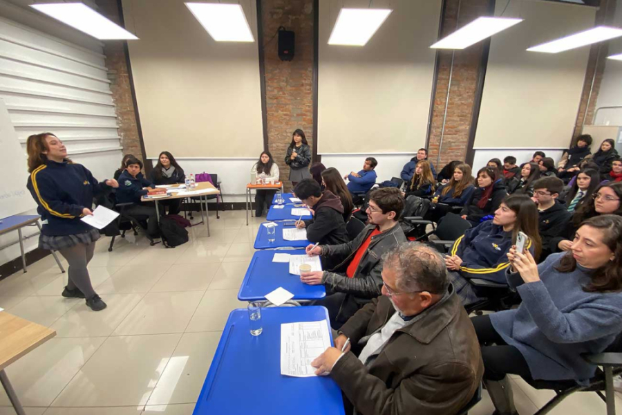 En la imagen aparecen estudiantes debatiendo de fislosofía frente a los profesores Usach que son jurados del torneo