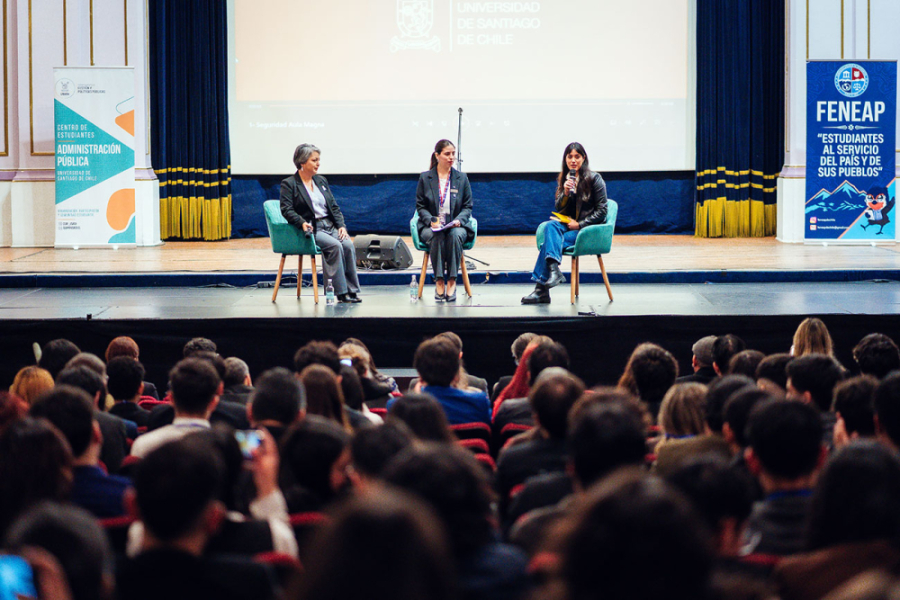 En la imagen aparece la académica Usach, Jeanette Jara junta a estudiantes de Administración Pública en el escenario del Teatro Aula Magna