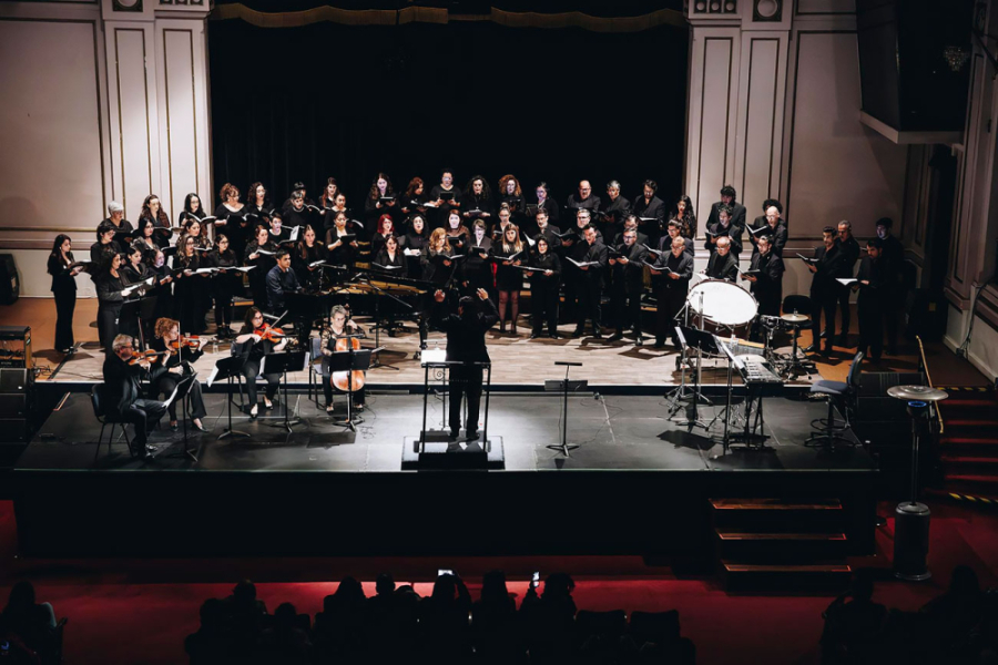 En la imagen aparece el Coro Usach en el Teatro Aula Magna de la Corporación