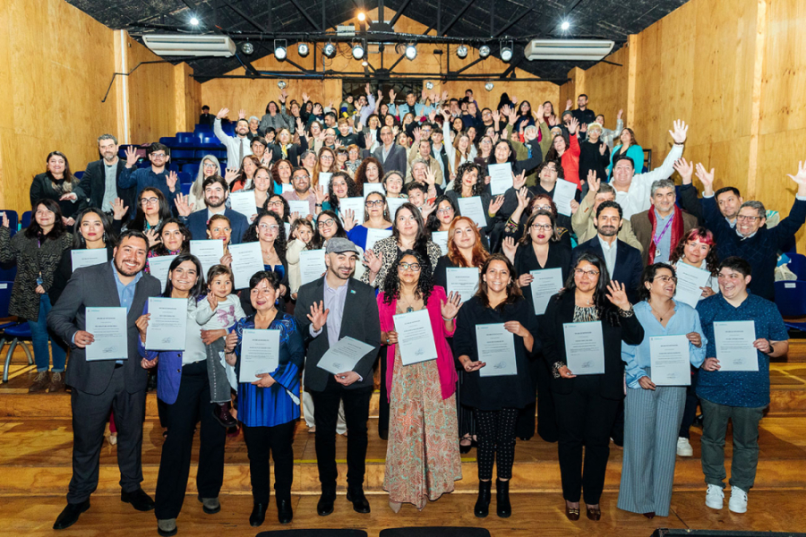 En la imagen aparecen estudiantes y docentes del diplomado mostrando sus certificados. Están en la Sala de las Artes Víctor Jara de la universidad.