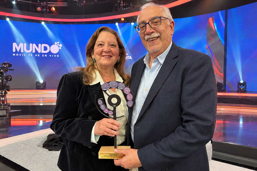 En la imagen aparecen la Dra. María José Galotto y el Dr. Abel Guarda, quienes posan a la cámara portando un trofeo  de reconocimiento.