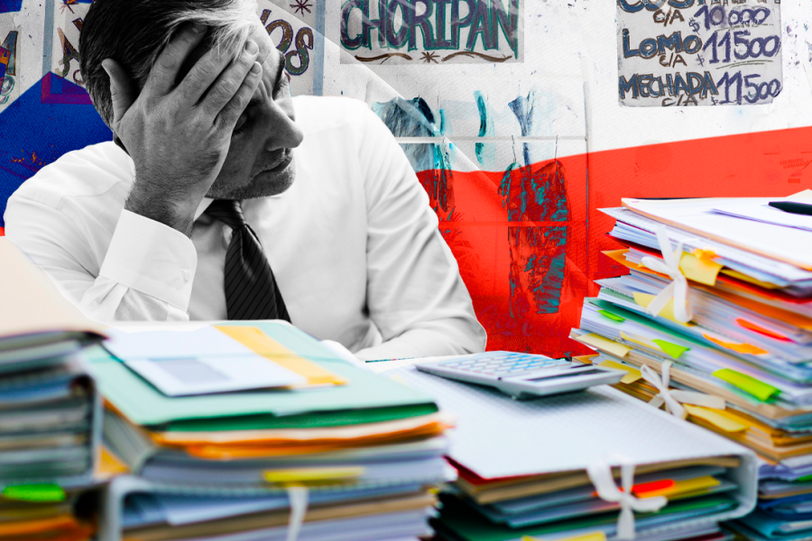 Persona agobiada por el trabajo pendiente sobre su escritorio